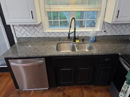a kitchen with granite countertop a sink and a window
