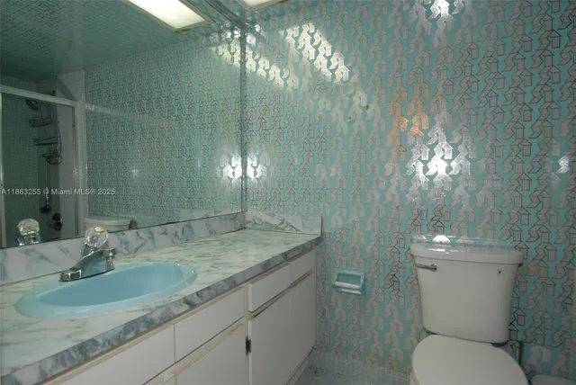 a bathroom with a toilet sink and mirror