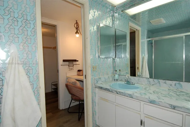 a bathroom with a granite countertop sink toilet and shower