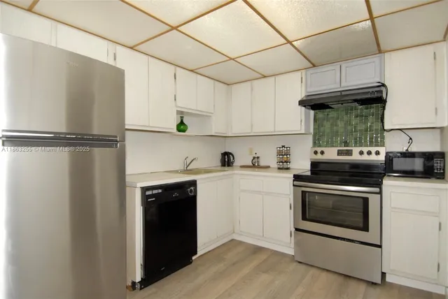 a kitchen with stainless steel appliances a refrigerator sink and cabinets