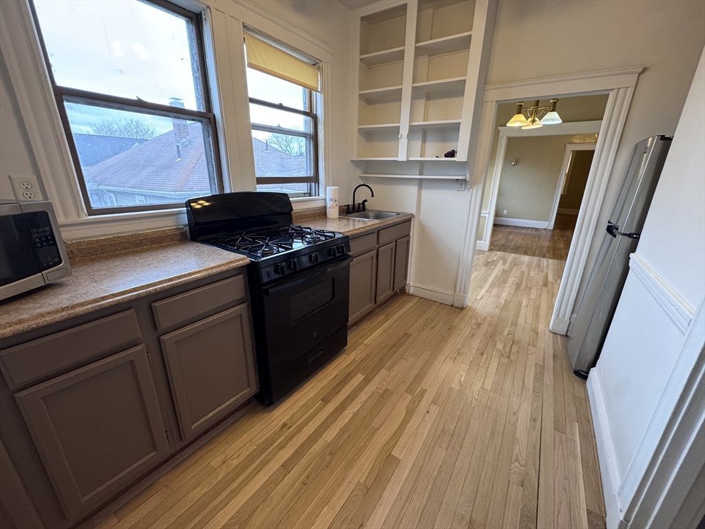 a kitchen with a sink a wooden floor and a window