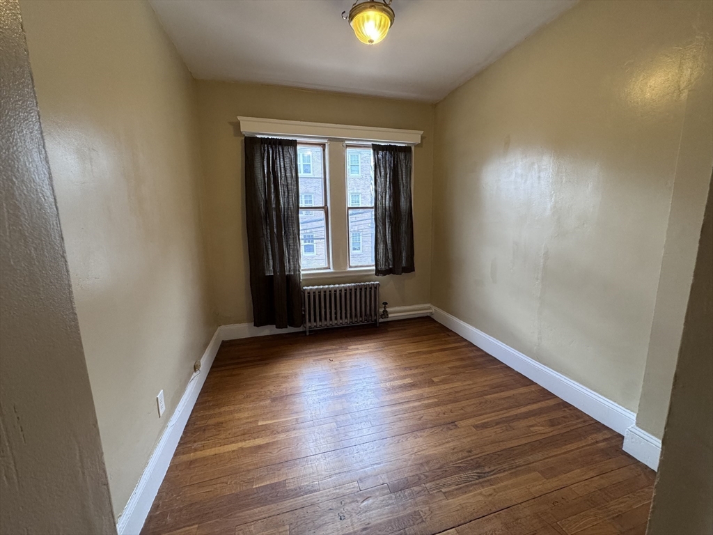 43-45 Cheney Street, Unit 3 Boston, MA 02121 - Photo 12 of 16 wooden floor in an empty room with a window