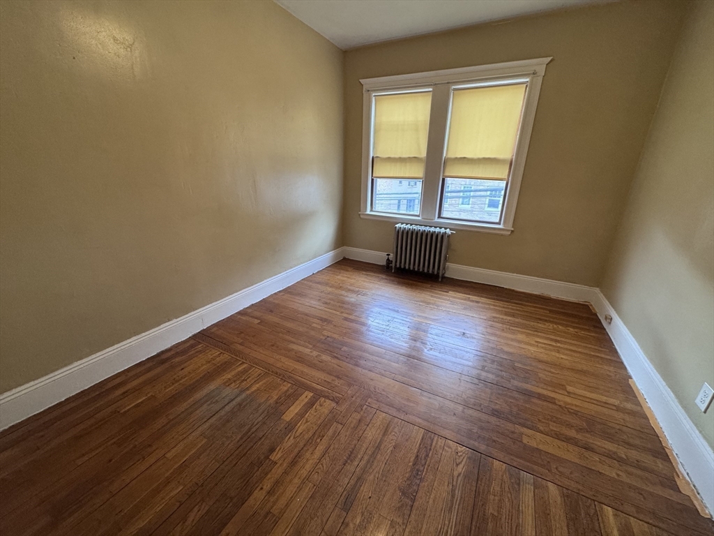 43-45 Cheney Street, Unit 3 Boston, MA 02121 - Photo 15 of 16 a view of an empty room with wooden floor and a window