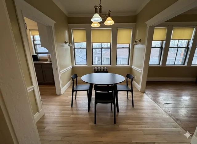 a dining room with wooden floor a chandelier a glass table and chairs