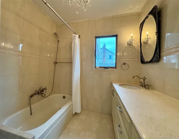 a bathroom with a tub sink and mirror