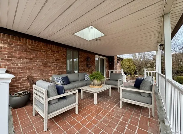 a outdoor living space with furniture potted plant and a large window
