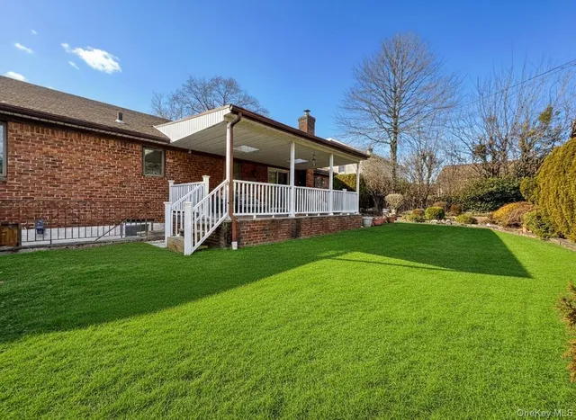 a front view of a house with a yard and trees