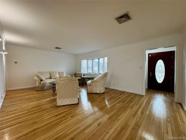 a living room with couches chairs and wooden floor