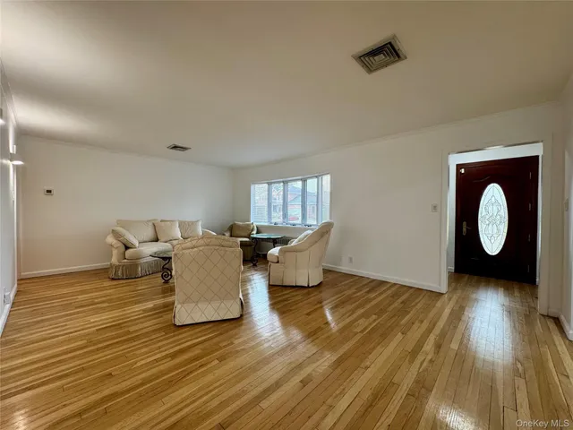 a living room with couches chairs and wooden floor