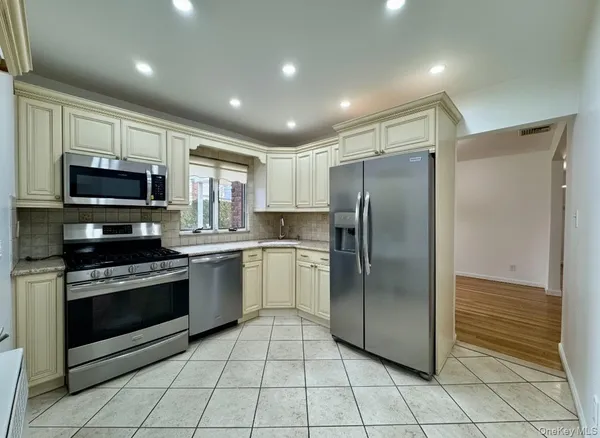 a kitchen with stainless steel appliances granite countertop a refrigerator and a stove top oven