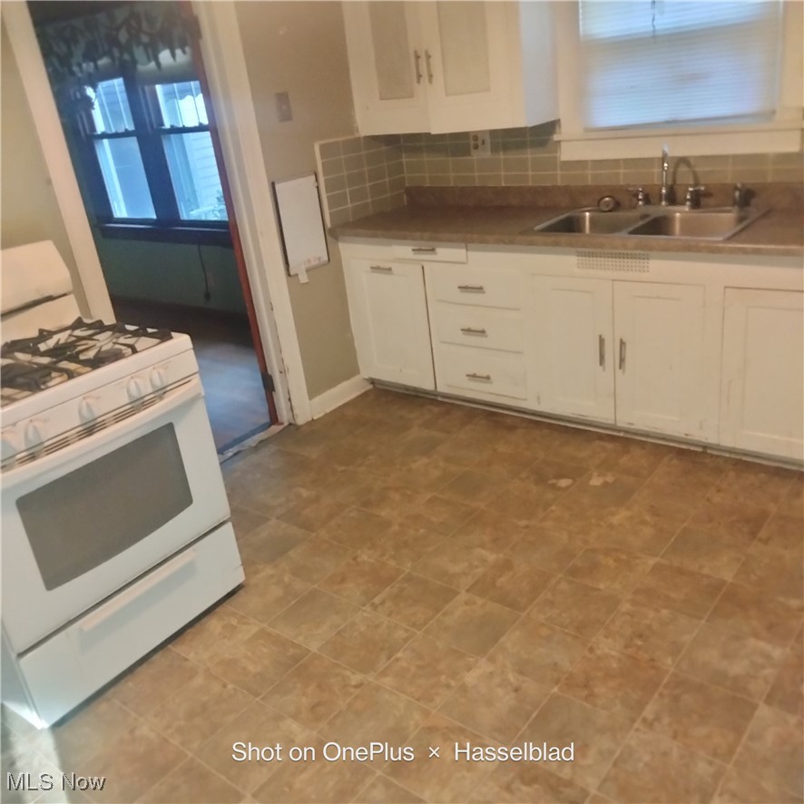1952 Hubbard Masury Road Hubbard, OH 44425 - Photo 18 of 20 Kitchen with white range with gas cooktop, tasteful backsplash, and white cabinets