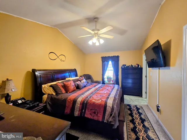 a bedroom with bed and flat screen tv