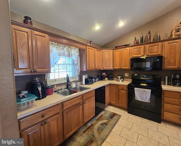 a kitchen with stainless steel appliances kitchen island granite countertop a sink dishwasher stove and cabinets