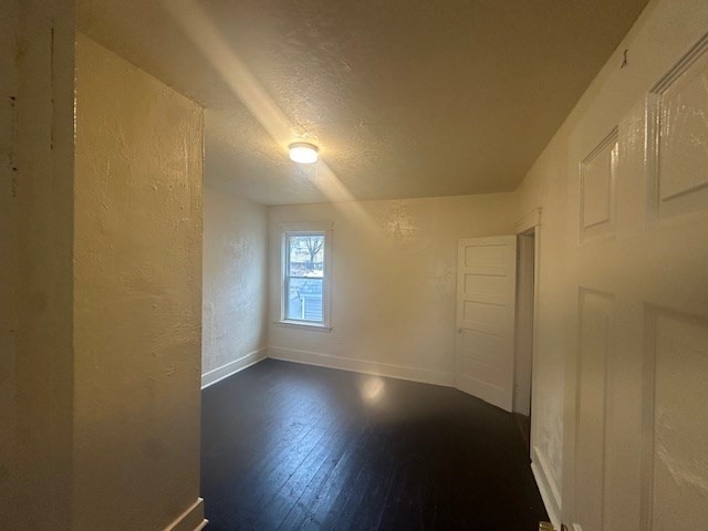 42 Dorcester, Unit 3 Worcester, MA 01604 - Photo 3 of 10 an empty room with wooden floor and windows with curtains