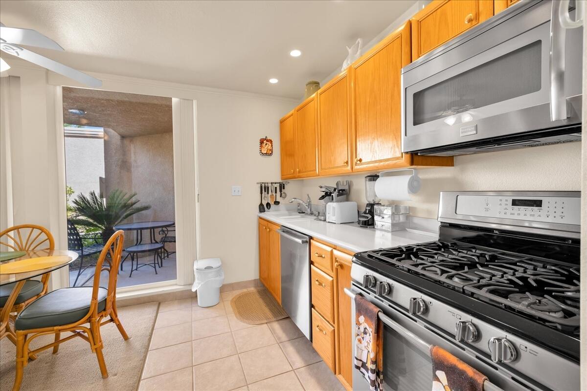1555 North Chaparral Road, Unit 334 Palm Springs, CA 92262 - Photo 12 of 36 a kitchen with stainless steel appliances granite countertop a stove a sink and a microwave