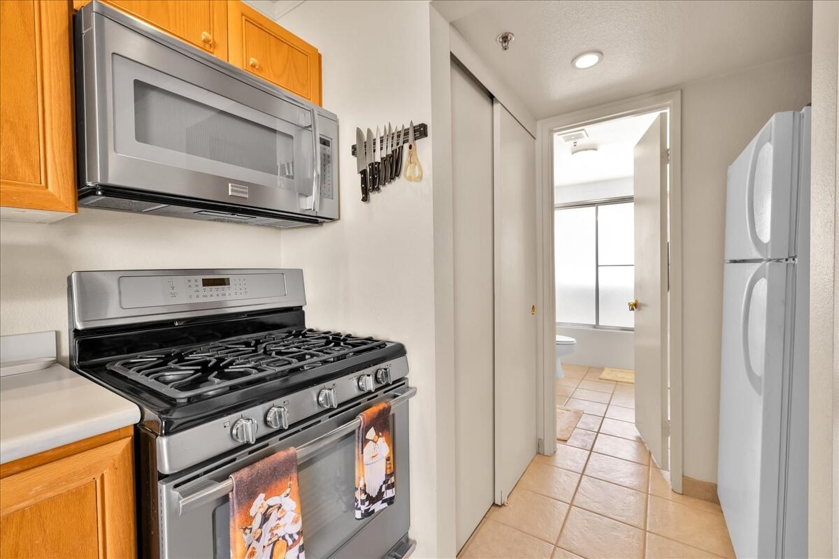 1555 North Chaparral Road, Unit 334 Palm Springs, CA 92262 - Photo 13 of 36 a kitchen with stainless steel appliances granite countertop a stove a sink and a microwave