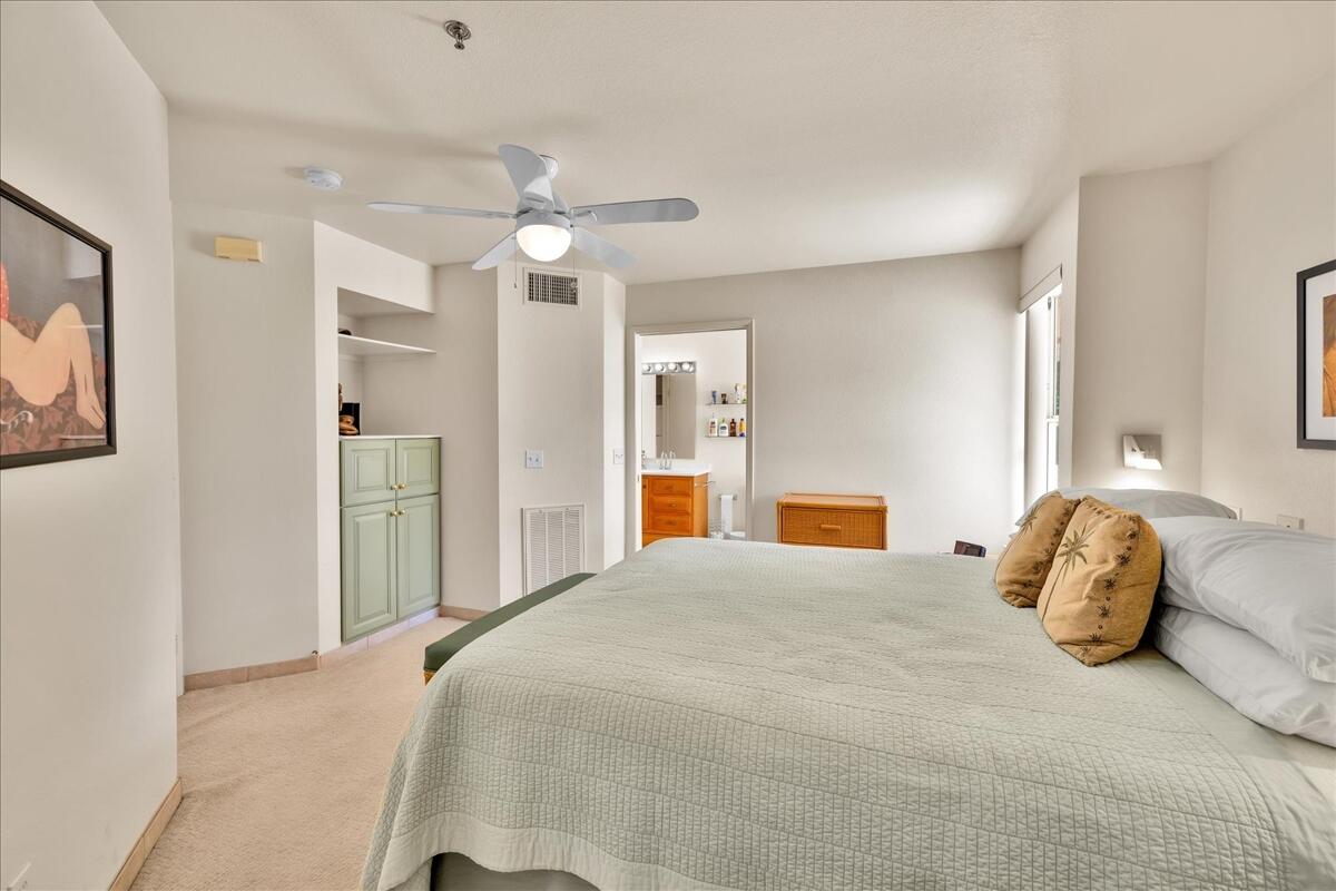 1555 North Chaparral Road, Unit 334 Palm Springs, CA 92262 - Photo 17 of 36 a bedroom with a large bed and a chandelier