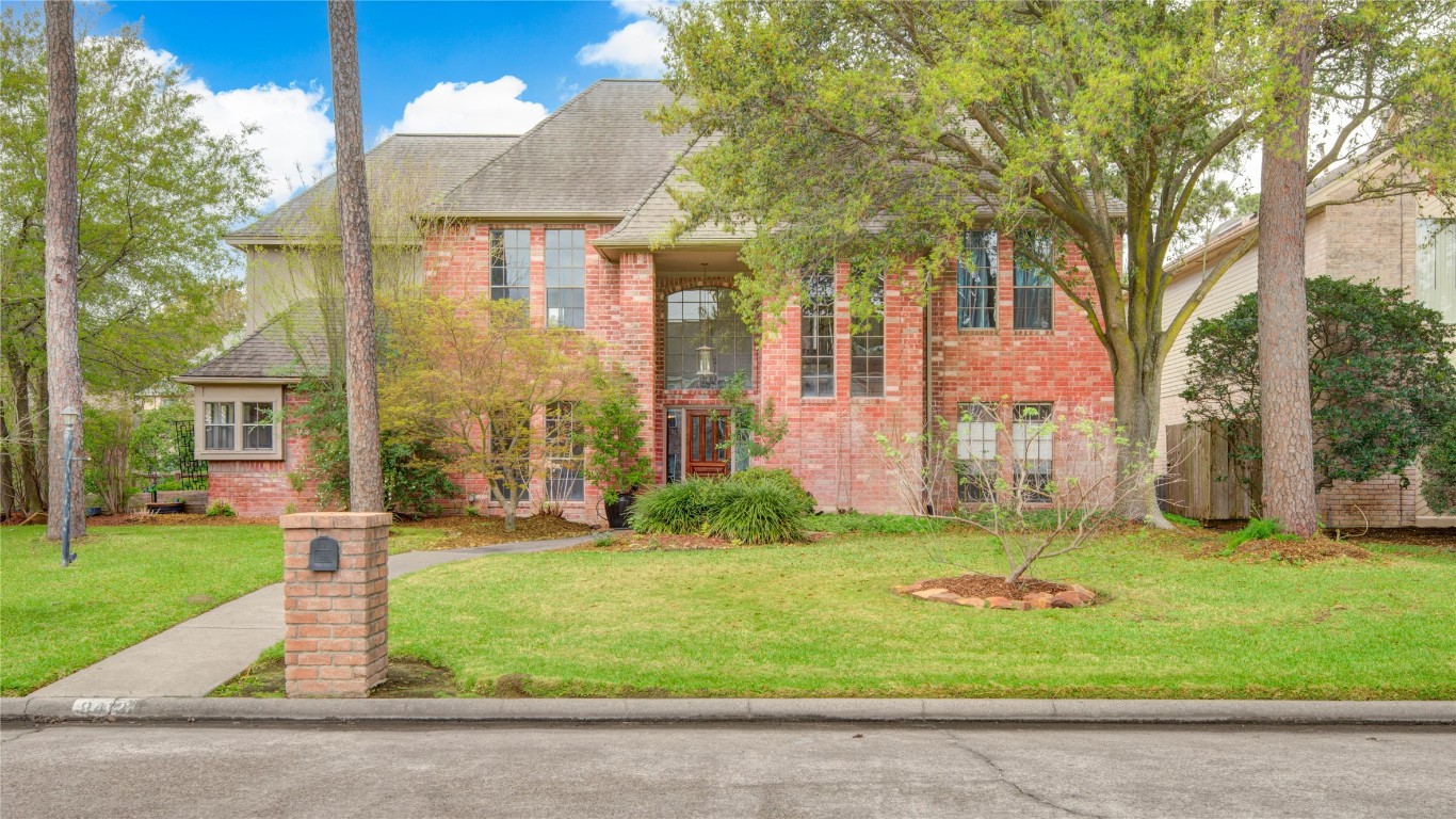 This majestic brick family home showcases a welcoming walkway leading to the recessed entry of the spacious front porch.