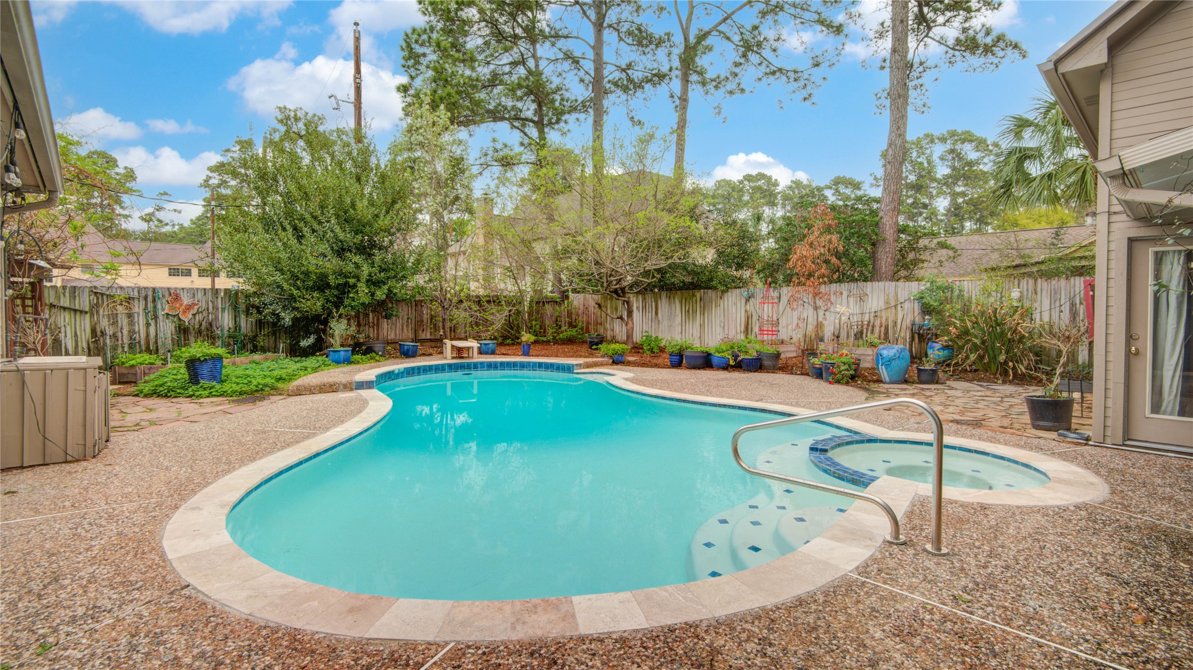 The private backyard retreat features a sparkling pool surrounded by mature trees, creating a peaceful setting for relaxing or entertaining.