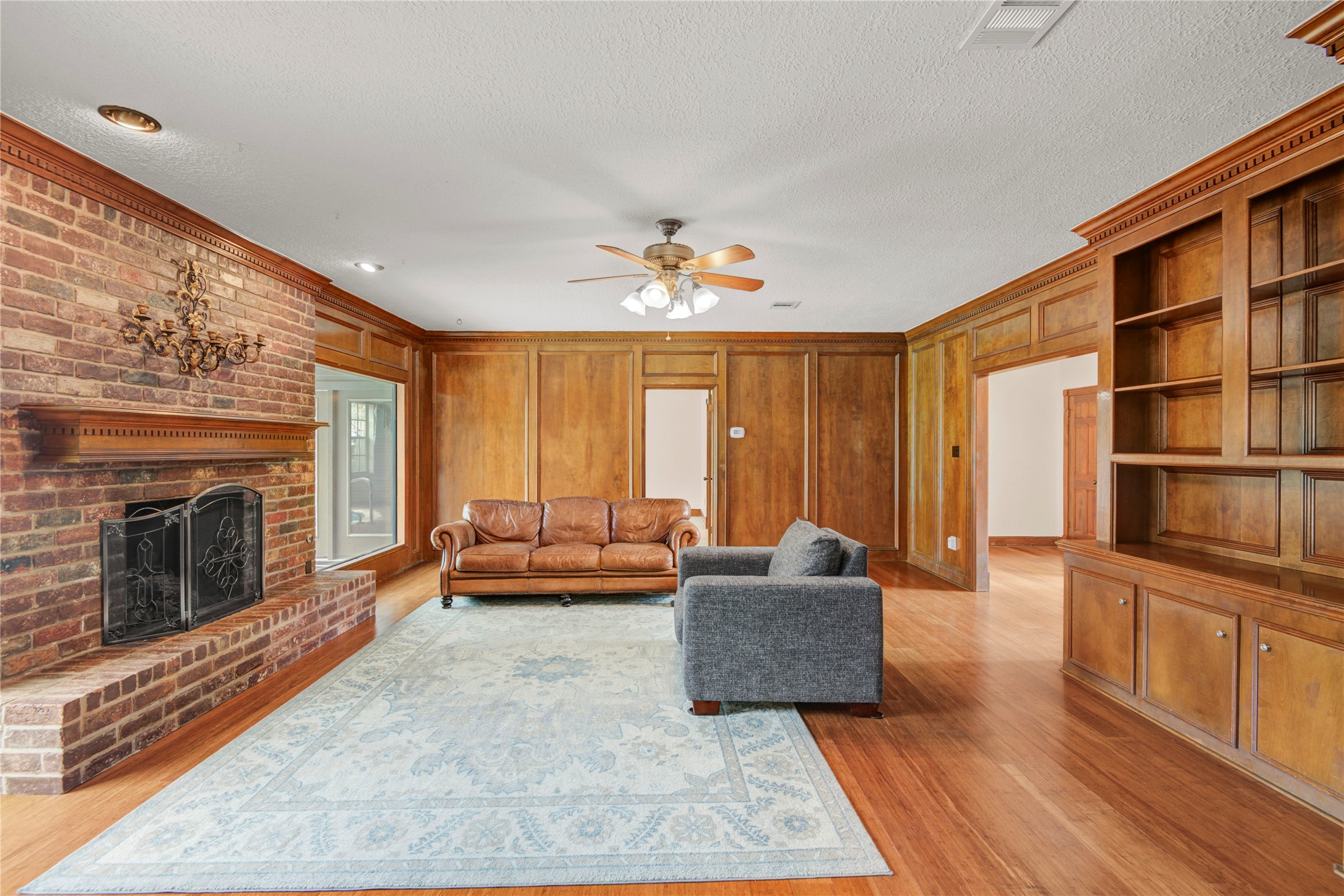 8412 Hidden Trail Lane Spring, TX 77379 - Photo 19 of 43 The spacious family room continues the rich bamboo flooring, custom built-ins, and a striking brick fireplace that anchors the space.