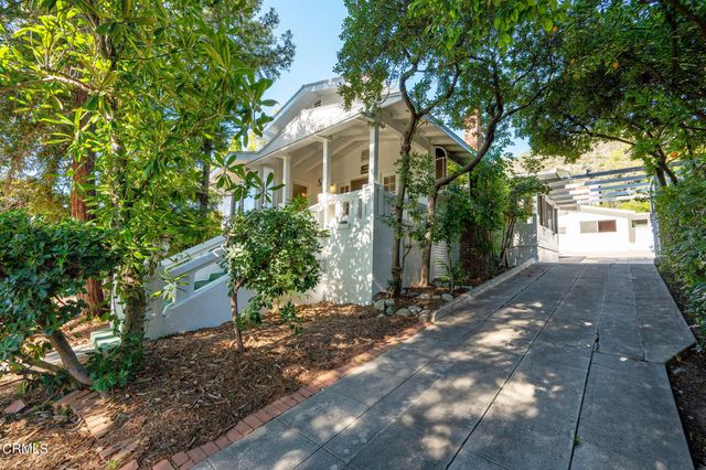 a front view of a house with a yard and tree
