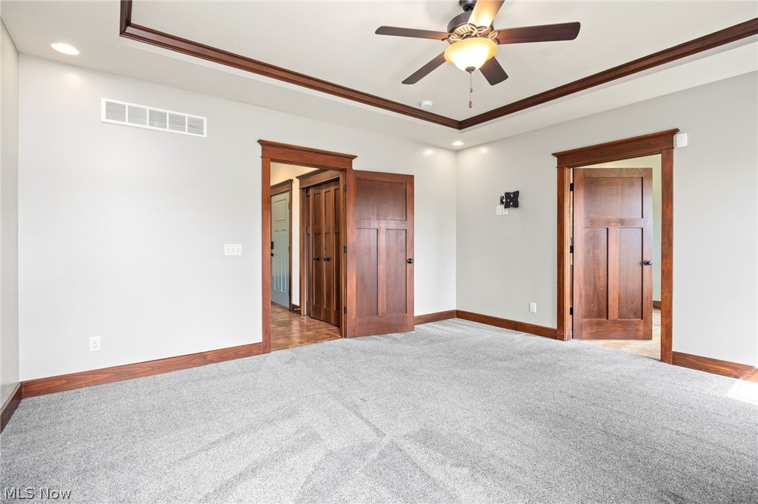 6925 River Styx Road Medina, OH 44256 - Photo 27 of 49 Spacious room featuring light gray carpeting, a tray ceiling with integrated lighting, and a ceiling fan