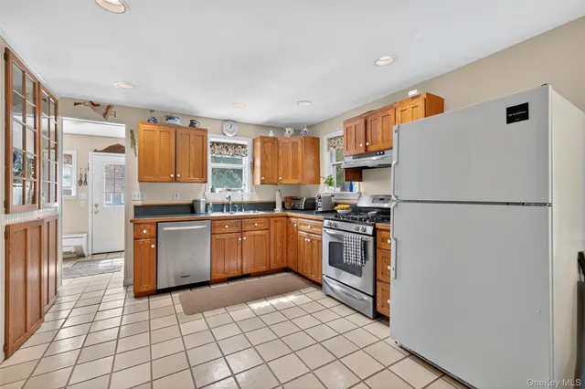 a kitchen with stainless steel appliances granite countertop a refrigerator sink and stove
