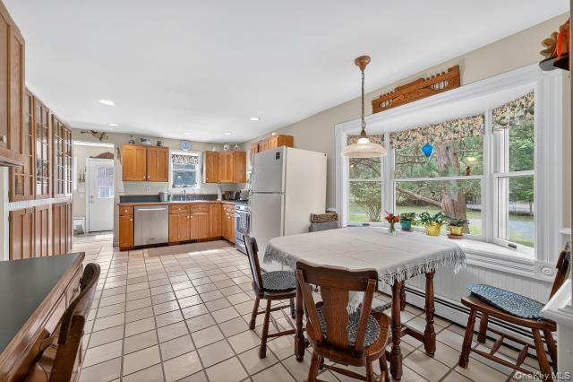 69 Smith Hill Road Airmont, NY 10952 - Photo 14 of 35 a open kitchen with stainless steel appliances granite countertop a stove top oven a sink dishwasher and white cabinets with wooden floors