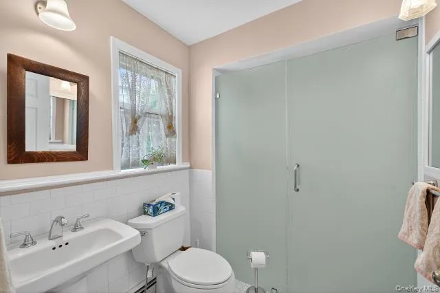a bathroom with a sink mirror and toilet