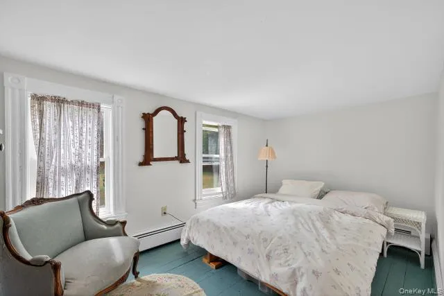 a bedroom with a bed chair and window