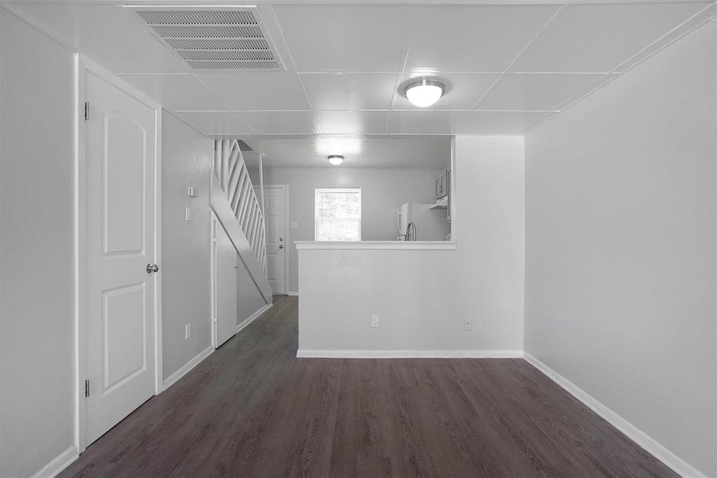 an empty room with wooden floor and a window