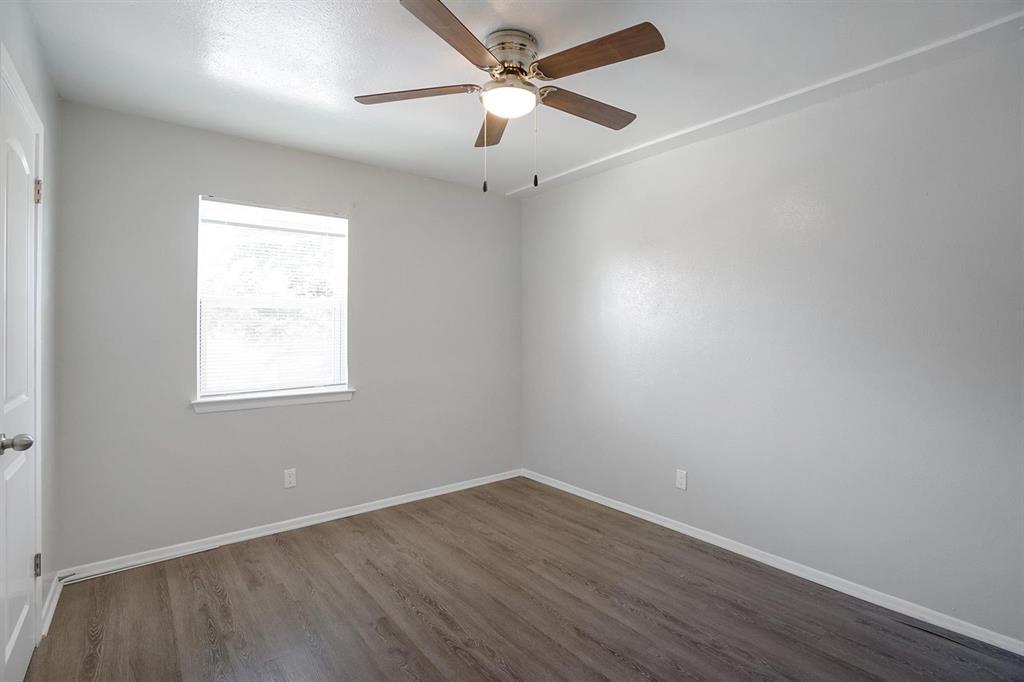 307 Rose Street, Unit 311C Arlington, TX 76010 - Photo 6 of 10 wooden floor in an empty room with a window