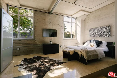 a living room with a bed furniture and a flat screen tv