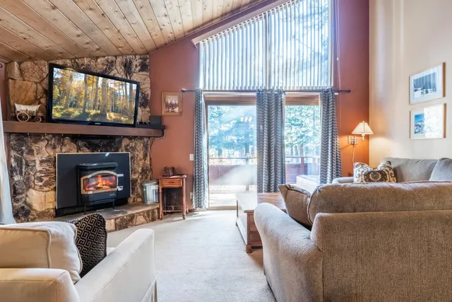 a living room with furniture a large window and a fireplace