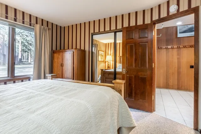 a bedroom with a bed lamp and a large window