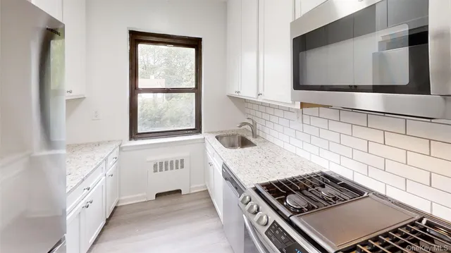 a kitchen with granite countertop a sink and a stove