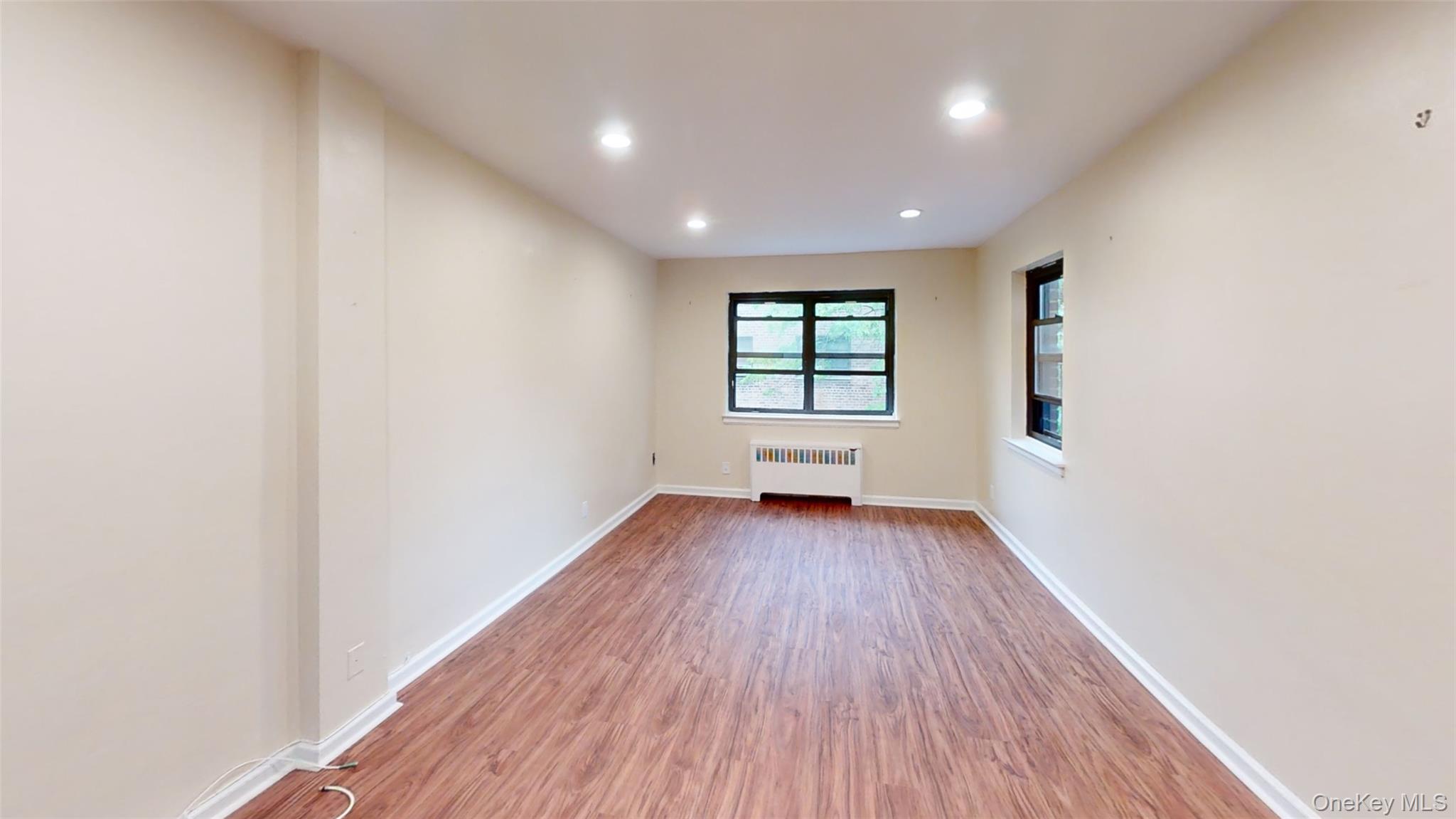 50 White Oak Street, Unit 4B New Rochelle, NY 10801 - Photo 3 of 20 an empty room with wooden floor and windows