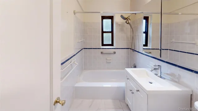 a bathroom with a tub sink and mirror
