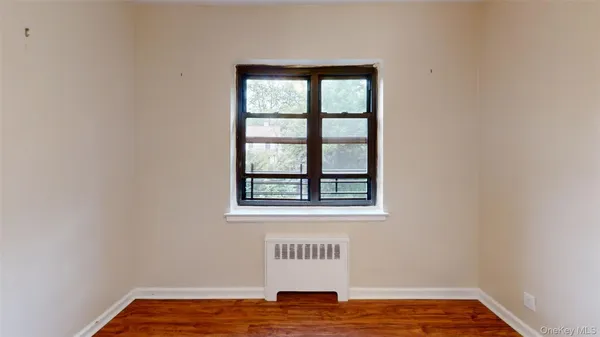 a view of a room with wooden floor and a window