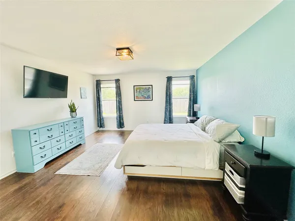 a bedroom with a bed and wooden floor