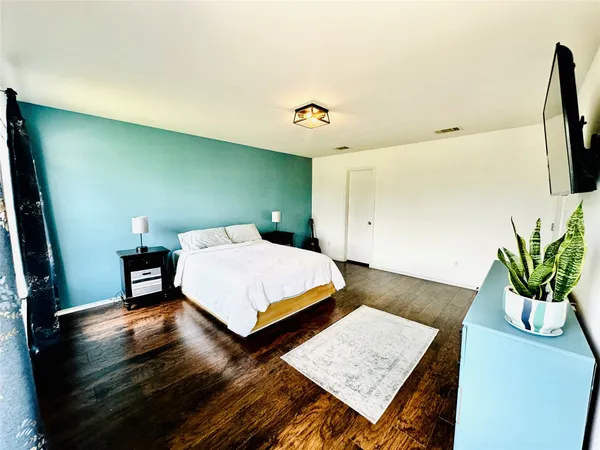 a bedroom with a bed and wooden floor