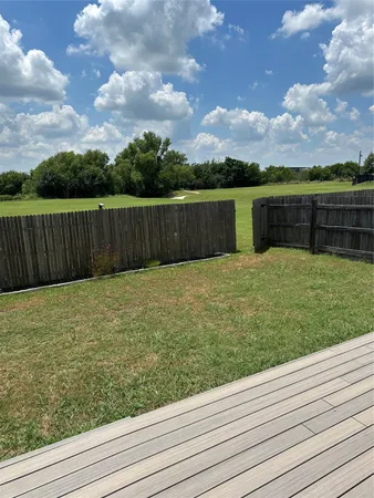 a view of a backyard with wooden fence