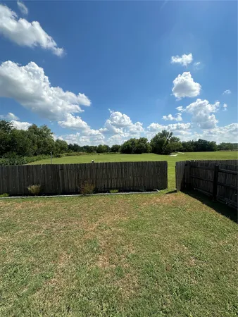 a view of a yard with wooden fence