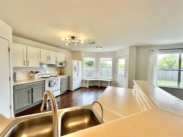 a living room with stainless steel appliances furniture and a large window