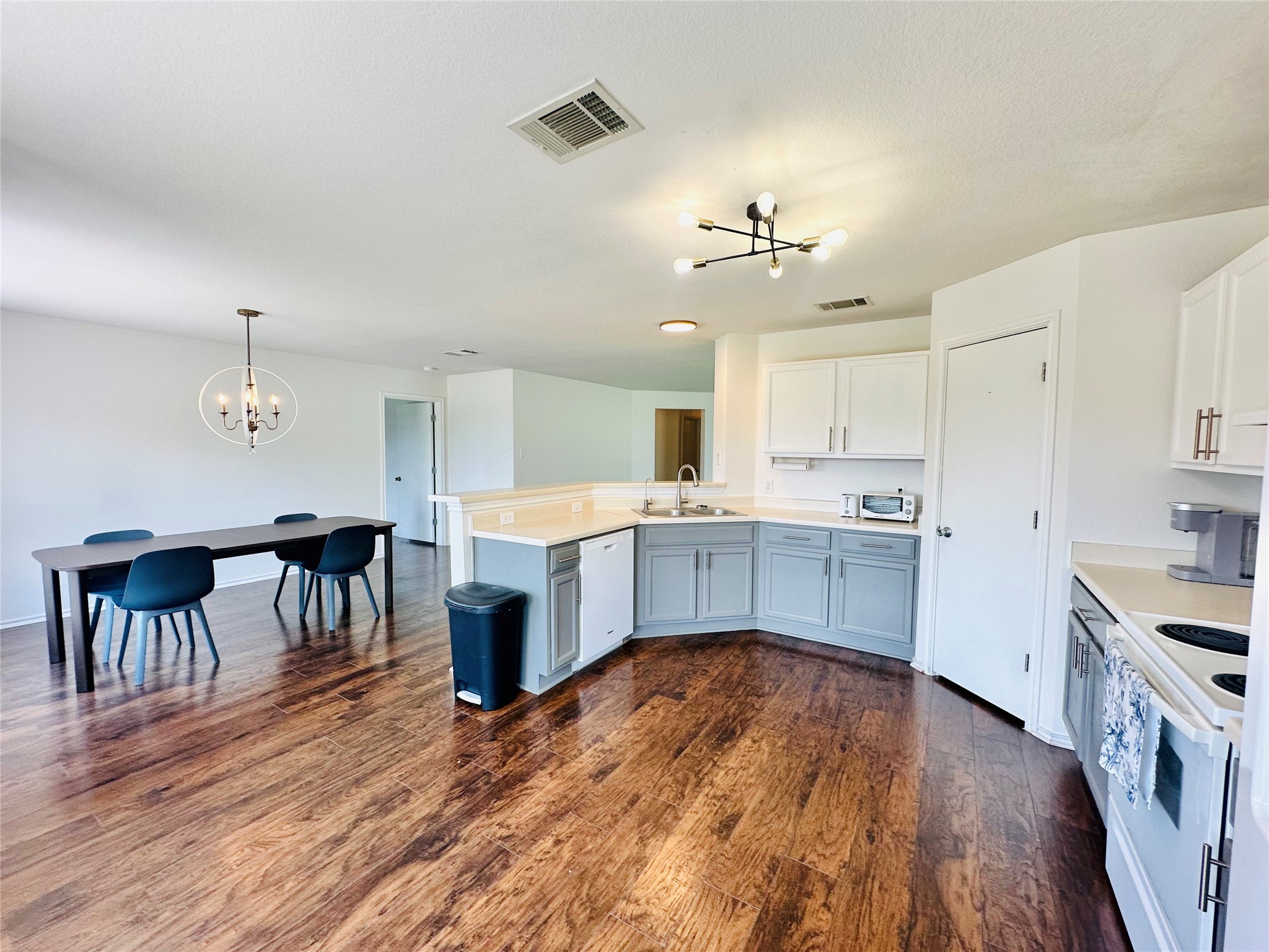602 Lavaca Loop Elgin, TX 78621 - Photo 10 of 28 a kitchen with a table chairs a sink dishwasher stove and cabinets with wooden floor