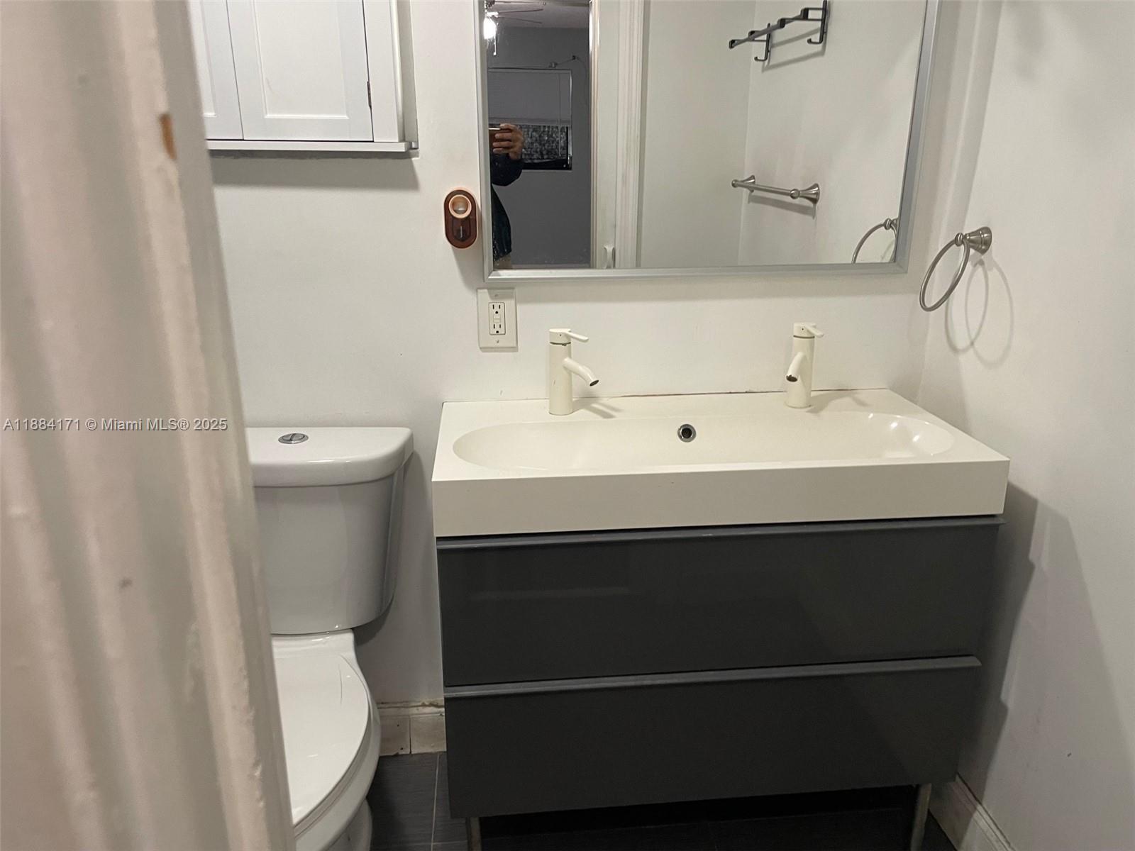 20201 Northeast 29th Court, Unit D112 Aventura, FL 33180 - Photo 12 of 17 a bathroom with a sink toilet and mirror