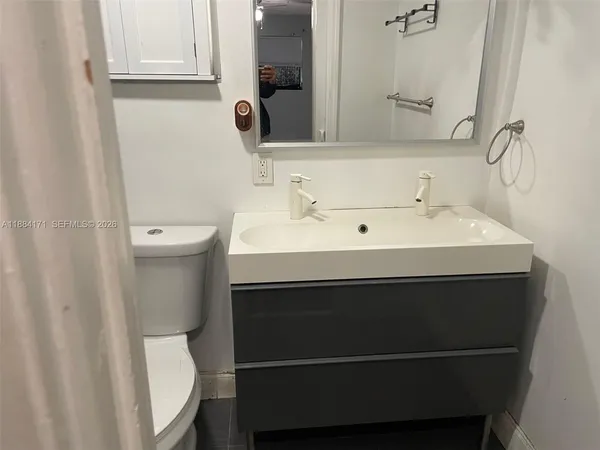 a bathroom with a sink toilet and mirror