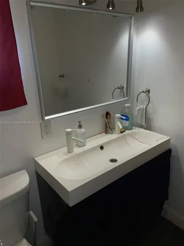 a bathroom with a sink vanity and a toilet