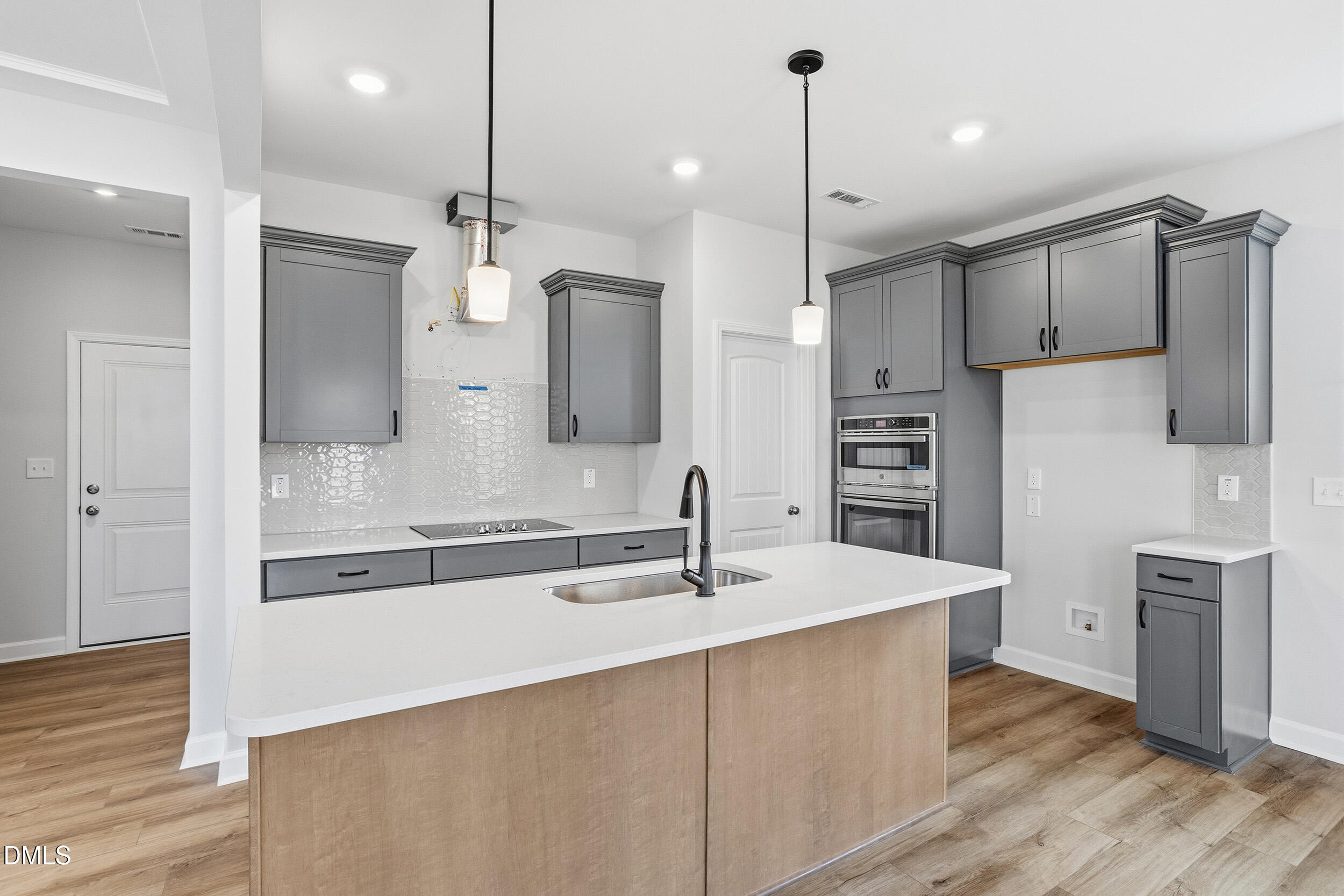 288 Meadowbark Bend, Unit 37 Garner, NC 27529 - Photo 10 of 50 a kitchen with kitchen island white cabinets and stainless steel appliances