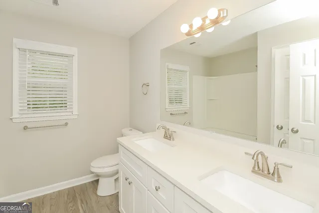 a bathroom with a sink vanity granite and toilet
